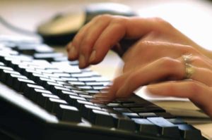 Person typing on keyboard.