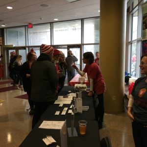 Students standing around table in group. 