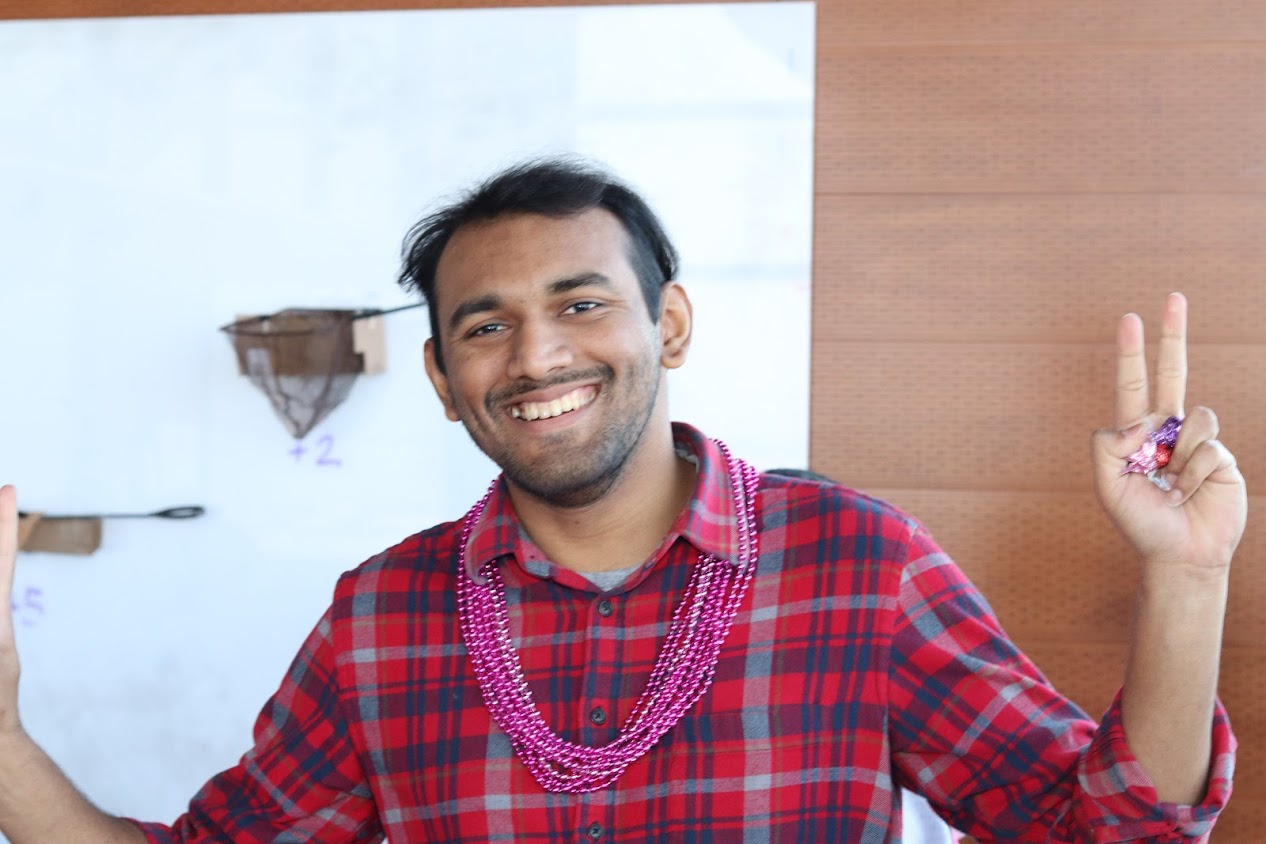 Student wearing red flannel shirt with pink necklaces to celebrate Valentine's Day.